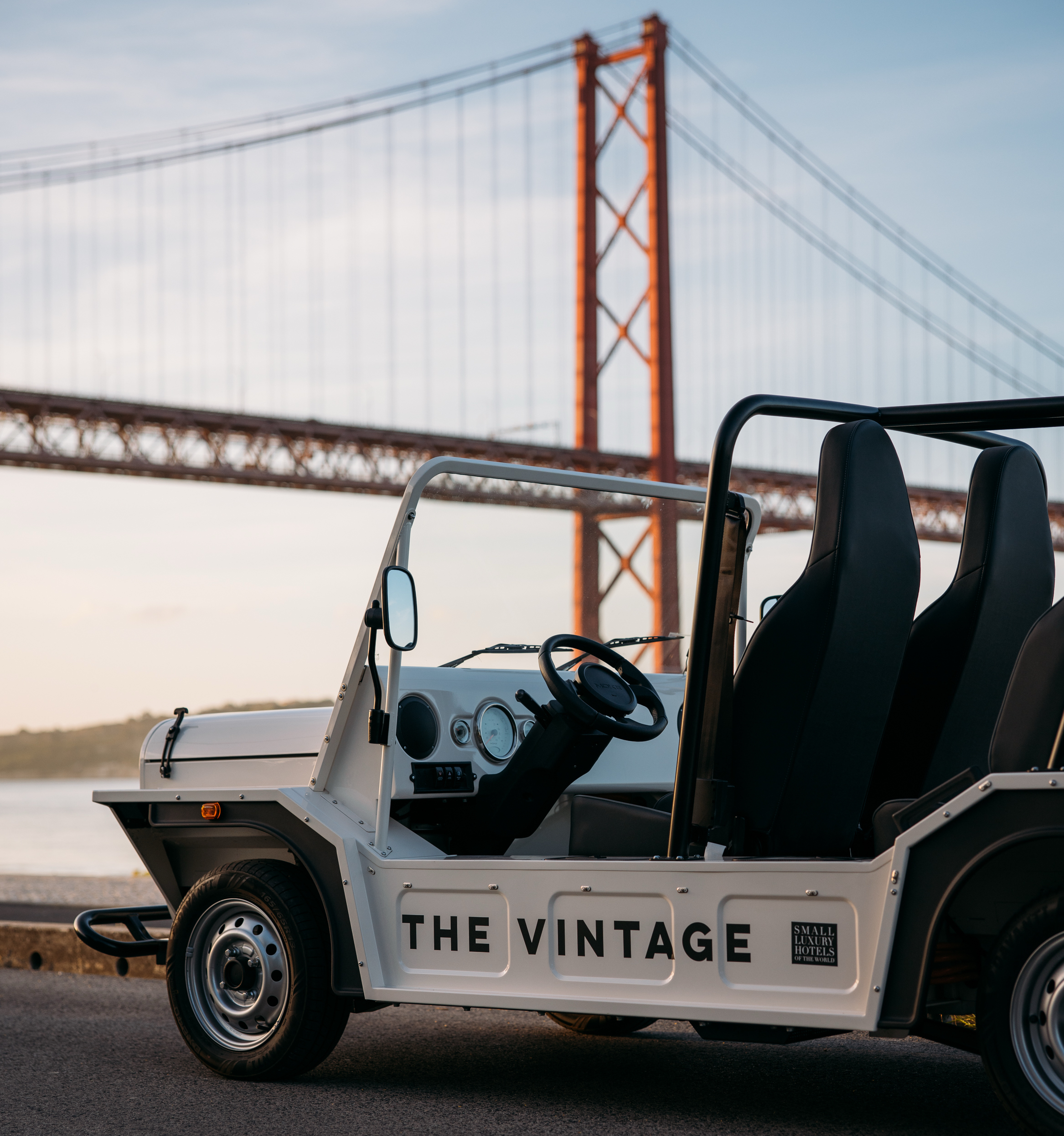 A white vintage-style open car labeled 