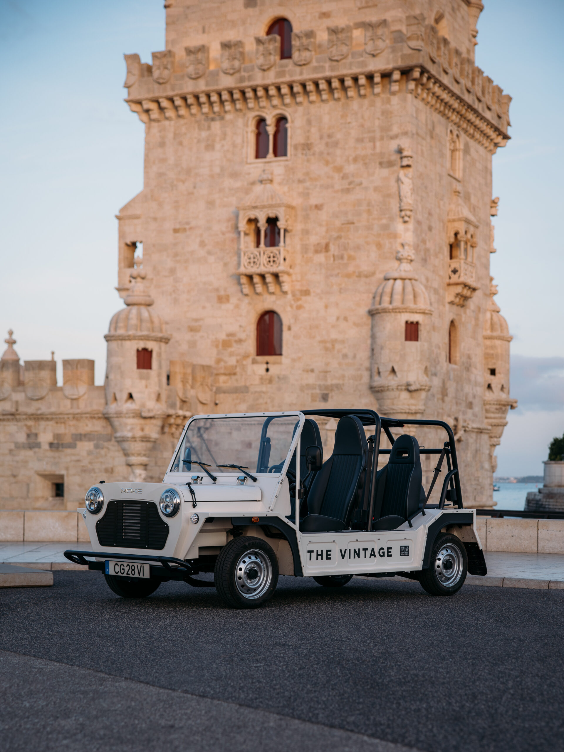 A white open-top vintage car with 